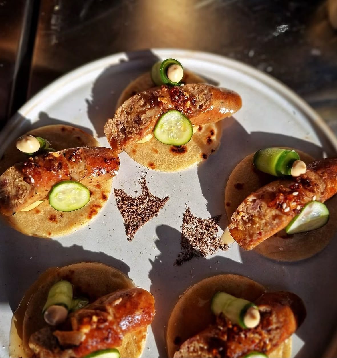 Gegrilde worst op een tortilla met komkommer